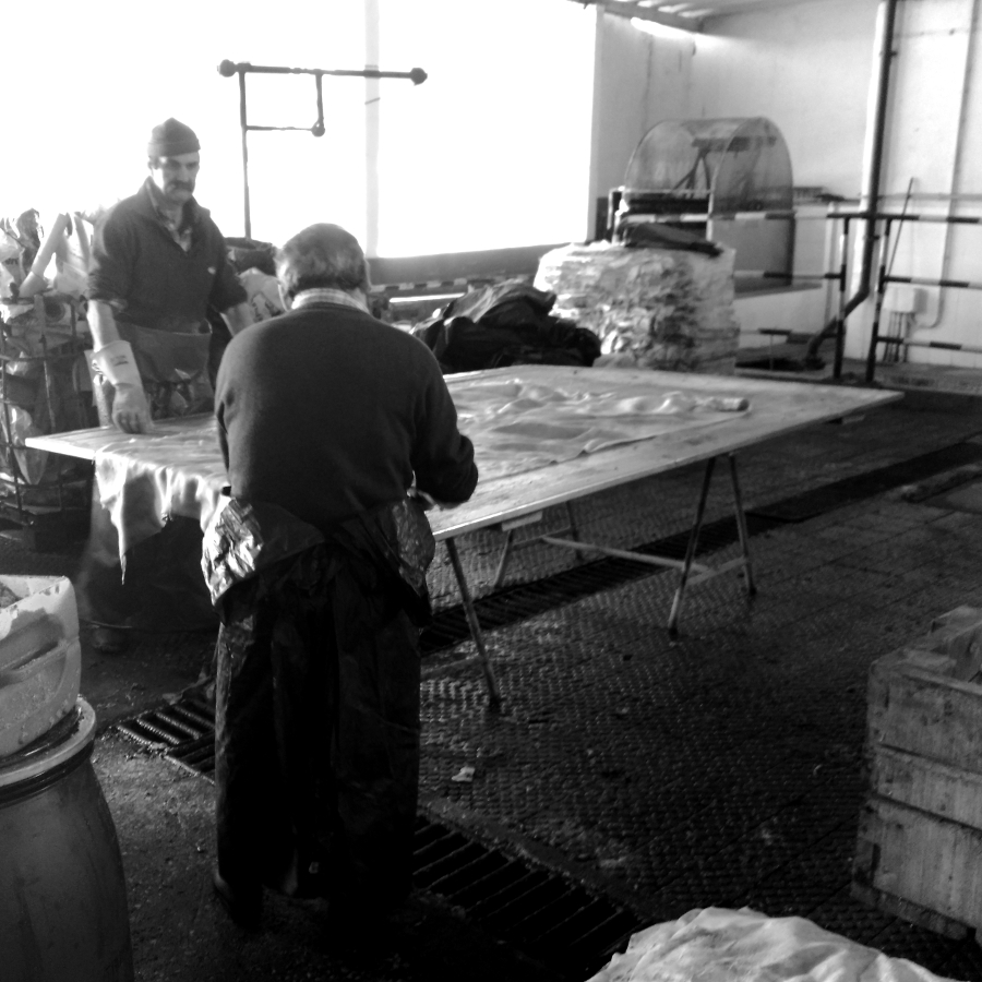 Men cutting raw leather material.